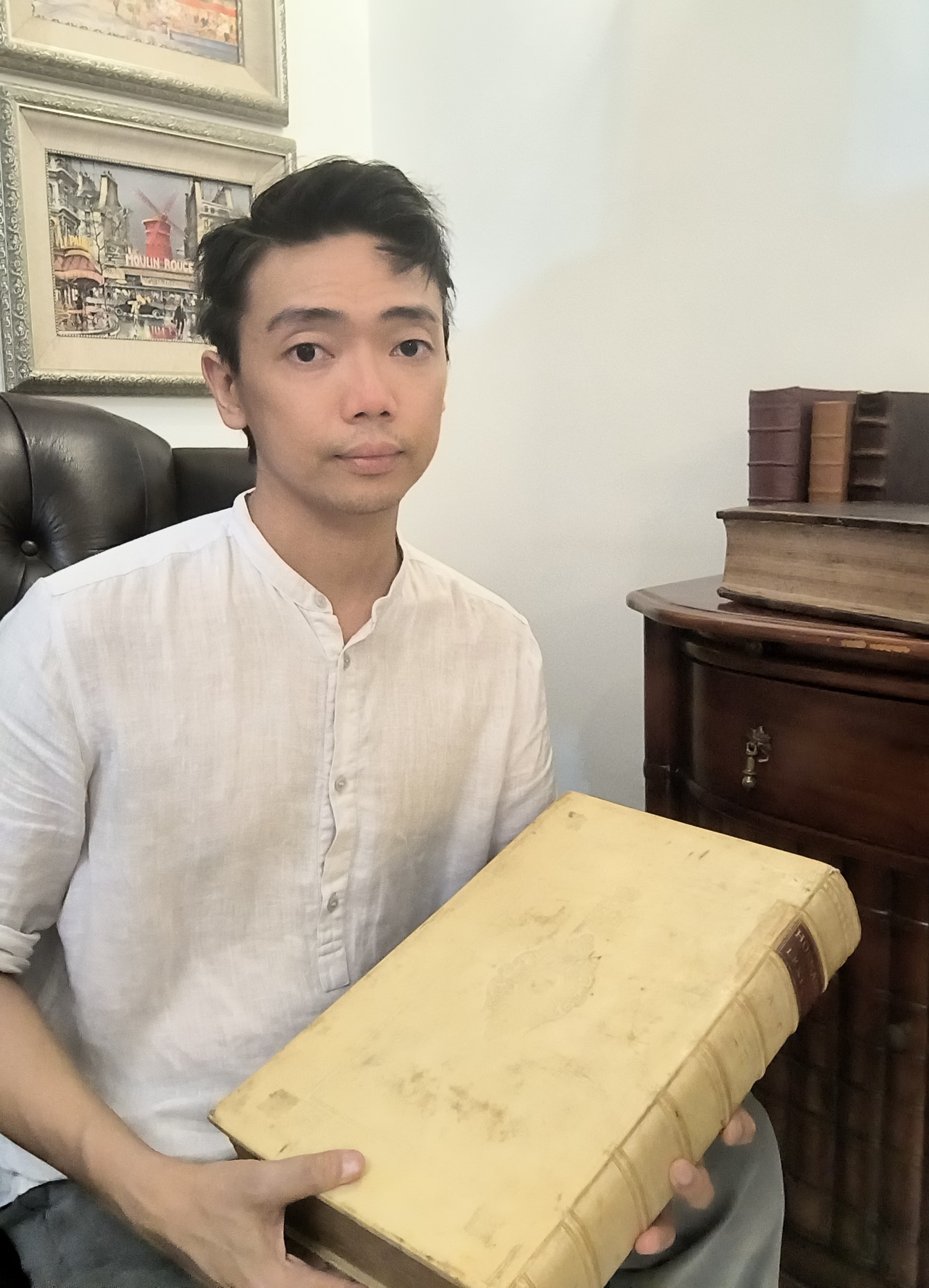 Luqman Azhar holding a 17th-century book